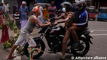 Ein Mann blockt einen Polizisten auf einem Motorrad, während Demonstranten, die die Versorgung mit lebensnotwendigen Gütern fordern, den zweiten Tag in Folge eine Kreuzung in Colombo blockieren. Auf Sri Lanka hat ein Generalstreik während der schlimmsten Wirtschaftskrise seit Jahrzehnten das öffentliche Leben weitgehend zum Stillstand gebracht. +++ dpa-Bildfunk +++