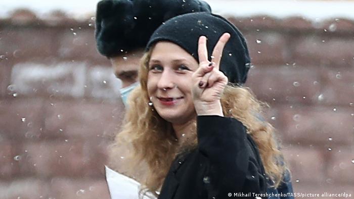 In this March 2018 file photo, Maria Alyokhina makes the peace sign with her hands while walking outside of a district court in Moscow