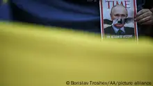 SOFIA, BULGARIA-MAY 09: A man holds a banner made as the cover of the TIME Magazine depicting Russian President Vladimir Putin as Adolf Hitler during a peaceful protest against the Russian attack on Ukraine in front of the Russian embassy in Sofia, Bulgaria, on May 09, 2022. Borislav Troshev / Anadolu Agency