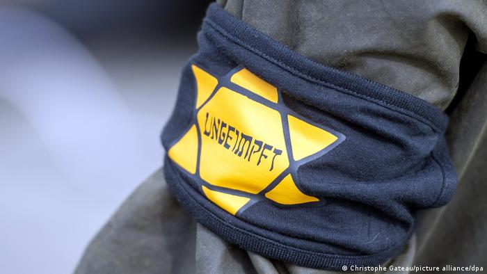 Traka sa žutom zvezdom na kojoj piše „nevakcinisan“ na ruci jednog od demonstranata u Berlinu