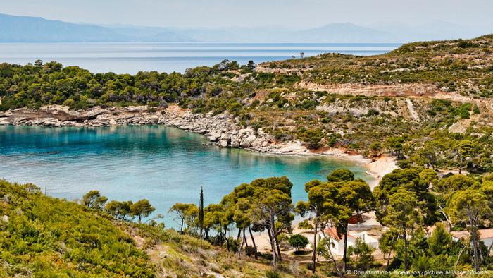 Agia Paraskevi beach is situated in a bay surrounded by trees.