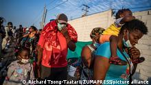 December 20, 2021, Tapachula, Chiapas, Mexico: Wearing face masks and carrying young children and their belongings, a Migrant Haitian family waits to board a bus Northbound on the side of a highway in Chiapas, Mexico. (Credit Image: © Richard Tsong-Taatarii/ZUMA Press Wire