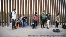 YUMA, ARIZONA , UNITED STATES - FEBRUARY 23: Asylum seekers from India, Cuba, and Colombia wait next to the USA border wall with Mexico, while being processed by USA border patrol in Yuma, Arizona, United States on February 22, 2022 . They wait for USA border patrol to arrive so they can turn themselves in. Yuma, Arizona. Katie McTiernan / Anadolu Agency