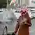 Saudi-Arabien Mann mit Turban schaut auf der Straße auf sein Smartphone