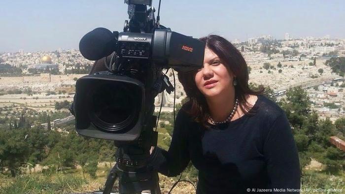 Shireen Abu Akleh, a journalist for Al Jazeera network, stands next to a TV camera with the Al-Aqsa Mosque in the Old City of Jerusalem in the background