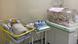 Stark white hospital room, one incubator, and a bassinet with a newborn baby Stark white hospital room, one incubator, and a bassinet with a newborn baby