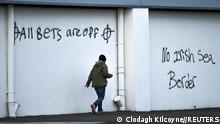 FILE PHOTO: Loyalist graffiti is seen with messages against the Brexit border checks in relation to the Northern Ireland protocol at the harbour in Larne, Northern Ireland February 12, 2021. REUTERS/Clodagh Kilcoyne//File Photo