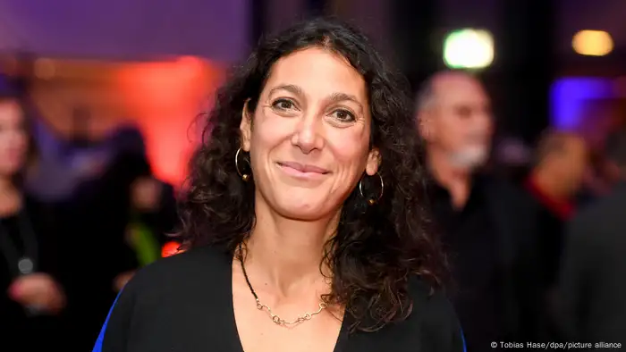 Emily Atef bei der Verleihung des Deutschen Regiepreises Metropolis in schwarzem Oberteil mit offenem, gelocktem braunen Haar