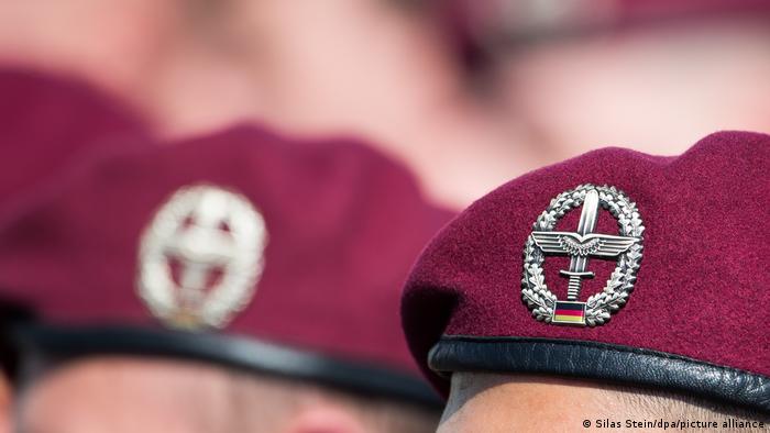 Close-up of burgundy berets on German soldiers with army aviators coat of arm visible