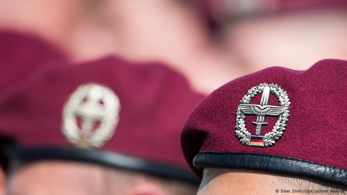 Close-up of burgundy berets on German soldiers with army aviators coat of arm visible