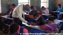 7.9.2020, Malawi, Ein Lehrer trägt eine Schutzmaske und hilft einem Schüler. Viele Schulklassen in Malawi haben wieder geöffnet, um die Schüler auf ihre nationale Abschlussprüfung in diesem Jahr vorzubereiten. +++ dpa-Bildfunk +++