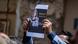 A man holds up a picture of Shireen Abu Akleh A man holds up a picture of Shireen Abu Akleh