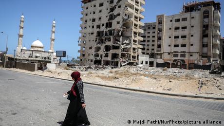 woman walks on a street in Gaza