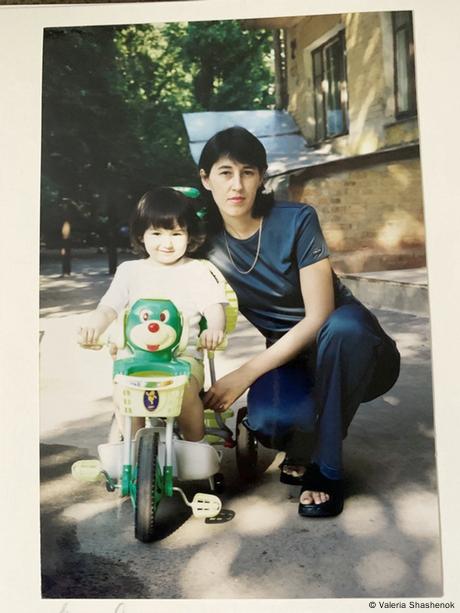 The child Shashenok on a training bicycle with her mother beside her