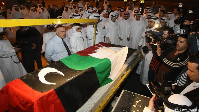 صورة لجنازة علي حسن الجابر وهو مغطى بالعلمين القطري والليبي.