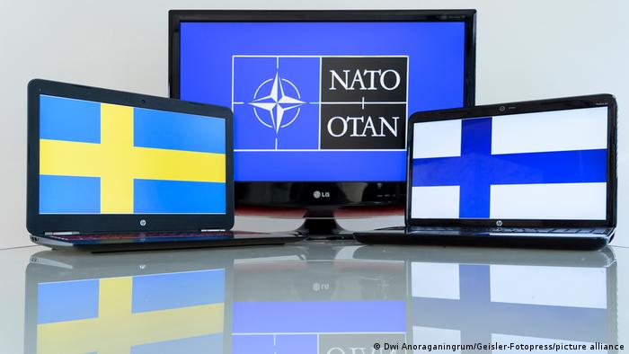 The flags of Sweden, NATO and Finland displayed on laptop screens