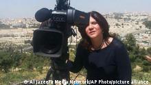 In this undated photo provided by Al Jazeera Media Network, Shireen Abu Akleh, a journalist for Al Jazeera network, stands next to a TV camera in an area where the Dome of the Rock shrine at Al-Aqsa Mosque in the Old City of Jerusalem is seen at left in the background. Abu Akleh, a well-known Palestinian female reporter for the broadcaster's Arabic language channel, was shot and killed while covering an Israeli raid in the occupied West Bank town of Jenin early Wednesday, May 11, 2022. (Al Jazeera Media Network via AP)