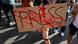 Protestor holding a sign that reads "press" and has red color drops imitating blood across it Protestor holding a sign that reads "press" and has red color drops imitating blood across it