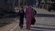 Kashmiri women along with children walk past parked vehicles of the Indian army Kashmiri women along with children walk past parked vehicles of the Indian army