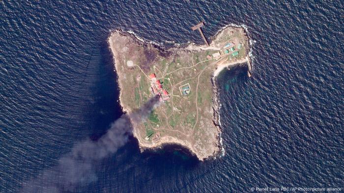 Snake Island in an aerial shot surrounded by the black sea with a plume of smoke rising