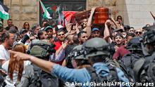 ***ACHTUNG Hinweis: Laut aktueller Berichterstattung ist bisher nicht geklärt, welche Seite den tödlichen Schuss abgegeben hat!***
Violence erupts between Israeli security forces and Palestinian mourners carrying the casket of slain Al-Jazeera journalist Shireen Abu Akle out of a hospital, before being transported to a church and then her resting place, in Jerusalem, on May 13, 2022. - Abu Akleh, who was shot dead on May 11, 2022 while covering a raid in the Israeli-occupied West Bank, was among Arab media's most prominent figures and widely hailed for her bravery and professionalism. (Photo by Ahmad GHARABLI / AFP) (Photo by AHMAD GHARABLI/AFP via Getty Images)