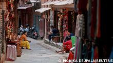 FILE PHOTO: Souvenir shop owners wait for customers at an alley in Bhaktapur, Nepal April 24, 2022. Picture taken April 24, 2022. REUTERS/Monika Deupala/File Photo