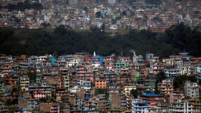 A tree line is pictured between the densely built houses and buildings of Kathmandu