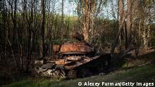 SLOBODA-KUKHARIVSKA, UKRAINE - MAY 10: A burnt Russian tank is seen in the woods, on May 10, 2022 near Sloboda-Kukharivska, Ukraine. The towns around Kyiv are continuing a long road to what they hope is recovery, following weeks of brutal war as Russia made its failed bid to take Ukraine's capital. As Russia concentrates its attack on the east and south of the country, residents of the Kyiv region are returning to assess the war's toll on their communities. (Photo by Alexey Furman/Getty Images)