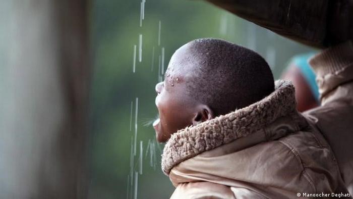 عکس منوچهر دقتی از کودکی در حال نوشیدن آب باران در اردوگاه آوارگان جنگی در کنیا