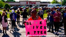 A woman holds a black lives matter sign