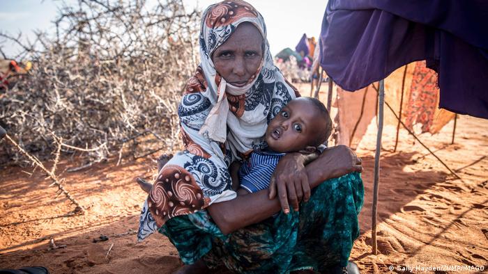 A Somali mother and her child sit in the shade 