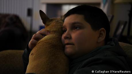Aidan Garza umarmt den Familienhund, während er TV schaut. REUTERS/Callaghan O'Hare 