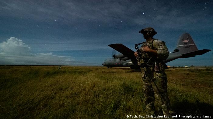 A US soldier provides security for a Super Hercules during unloading operations at an unidentified location in Somalia