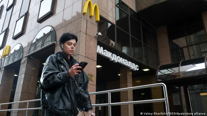 A young woman walks past a closed McDonald's restaurant in Tverskaya Street in Moscow