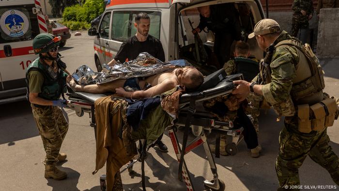 Volunteer medics transport a severely injured soldier