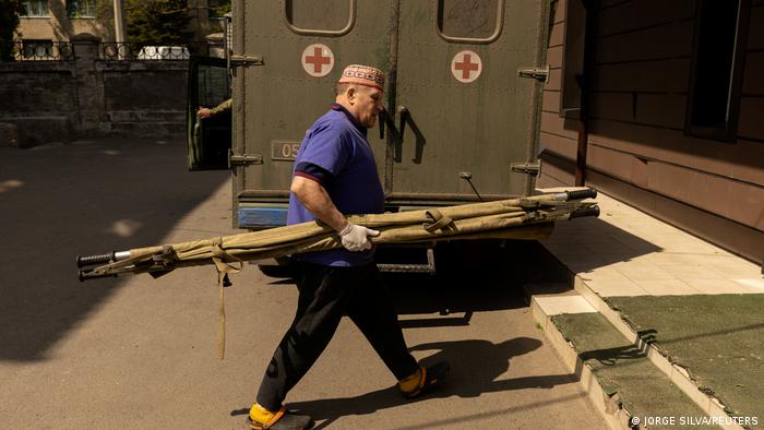 A medic carries a stretcher past an ambulance in Bakhmut, Ukraine 