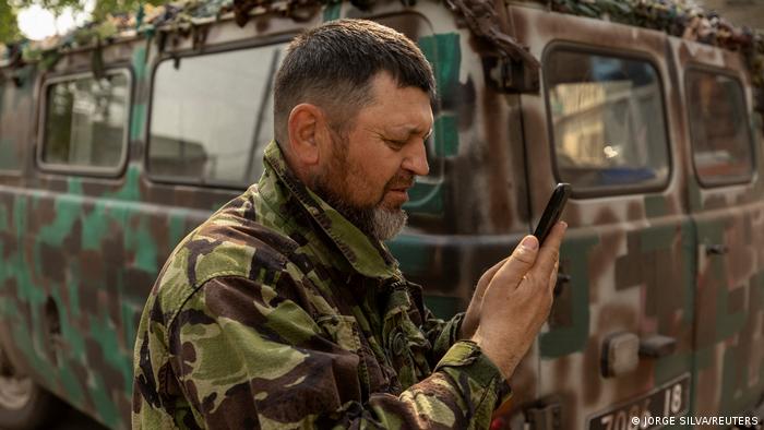 Soldier Alessandro stares into his cellphone as he waits to talk with his grandson in Poland