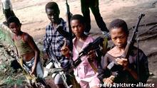 Kindersoldaten der Rebellengruppe Vereinigte Revolutionäre Front (RUF) im Oktober 1999 in einem Militärlager in Makeni nahe der Stadt Lunsar (Sierra Leone). Nach dem Abschluss des Friedensvertrages im Juli läuft die Entwaffnung der rund 45000 Kämpfer in Sierra Leone nur schleppend an. Unter den Kämpfern, die demobilisiert werden sollen, sind nach Schätzungen des UN-Kinderhilfswerkes Unicef mindestens 5000 Kinder. Sie wurden von allen Kriegsparteien an die Front geschickt, von den Rebellengruppen ebenso wie von den regierungstreuen Milizen.