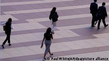 17.05.2022, Spanien, Madrid: Frauen gehen auf ein Bürogebäude in Madrid zu. Arbeiten trotz heftiger Unterleibsschmerzen während der monatlichen Regel - von dieser Tortur sollen Frauen in Spanien künftig befreit werden. Das sieht ein Gesetzentwurf der linken Regierung vor, der am Dienstag im Kabinett offiziell vorgestellt werden soll. Demnach sollen Spanierinnen das Recht bekommen, in solchen Fällen zu Hause bleiben zu können. Foto: Paul White/AP/dpa +++ dpa-Bildfunk +++