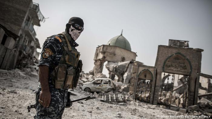  An Iraqi police man stands at the remains of the Al-Nuri mosque, where the Islamic State caliphate was proclaimed, in the old city of Mosul, Iraq