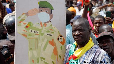 A supporter of Malian Interim President holds up the flag of Mali during a pro-junta and pro-Russia rally in Bamako.
