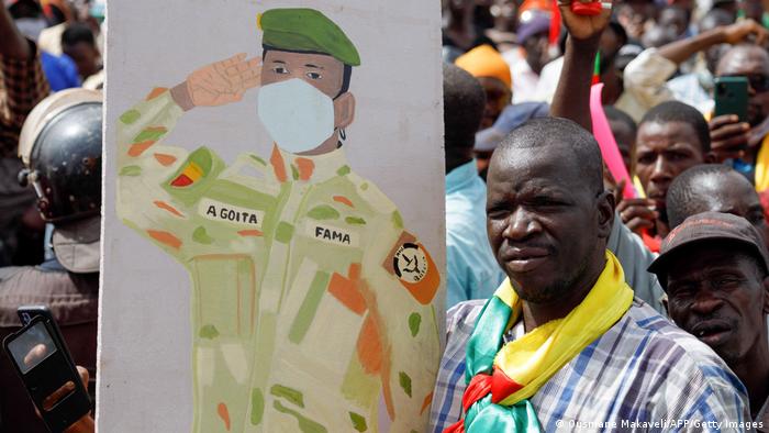 A supporter of Malian Interim President holds up the flag of Mali during a pro-junta and pro-Russia rally in Bamako.
