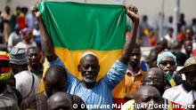 A supporter of Malian Interim President holds up the flag of Mali during a pro-Junta and pro-Russia rally in Bamako on May 13, 2022. - Several hundred Malians have gathered in Bamako to support the junta, the army and military cooperation with the Russians, AFP journalists report. (Photo by OUSMANE MAKAVELI / AFP) (Photo by OUSMANE MAKAVELI/AFP via Getty Images)