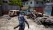 Homem anda em frente a carros queimados em Port-au-Prince Homem anda em frente a carros queimados em Port-au-Prince