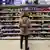A woman looks at products on a supermarket shelf