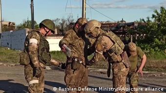Российские военные обыскивают украинского солдата на Азовстали в Мариуполе