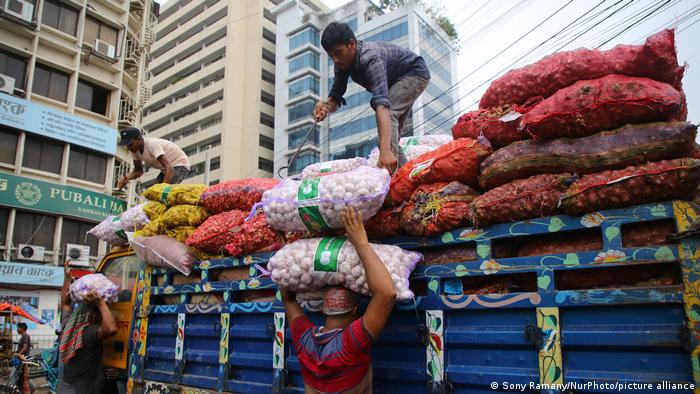 People work at an onion wholesale market in the Kawran Bazar in Dhaka