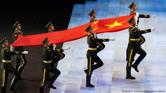 Chinese soldiers carry the Chinese flag up a flight of stairs