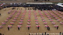 An aerial picture shows mourners gathering around coffins wrapped with the Iraqi flag during a mass funeral for Yazidi victims of the Islamic State (IS) group in the northern Iraqi village of Kojo in Sinjar district, on February 6, 2021. - The remains of 104 Yazidi victims of the Islamic State group have been returned for burial in Kojo, six years after the IS group swept through northern Iraq. (Photo by Zaid AL-OBEIDI / AFP) (Photo by ZAID AL-OBEIDI/AFP via Getty Images)