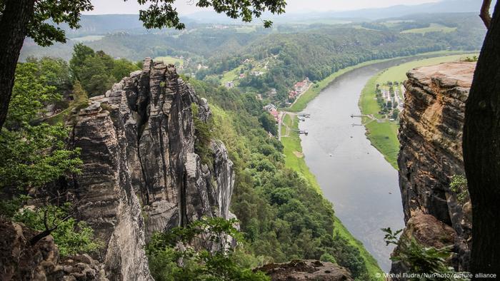 A view of the valley in Saxony Switzerland with sandstone rock formations visible.